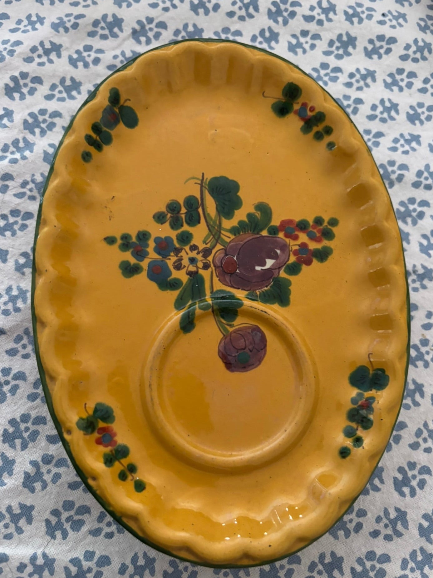 Yellow ceramic plate with floral design on a patterned tablecloth
